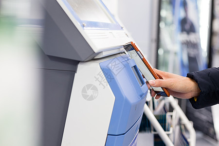 机器手妇女通过NFC连接移动电话和售票机背景