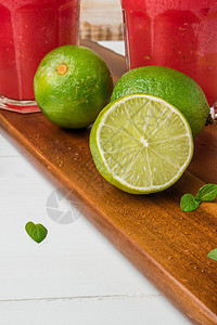 新鲜的成熟石灰柠檬榨汁机桌子饮食果汁叶子木板水果茶点用具图片