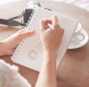 在笔记本上写笔笔的女子手桌子作家太阳日记新闻业阳光写作学生教育笔记图片