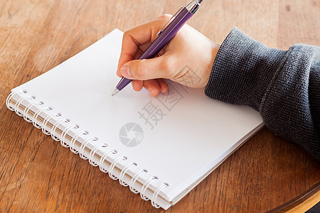 在笔记本上写笔笔的女子手经理报告学生教育阳光笔记新闻业脚本太阳文书图片