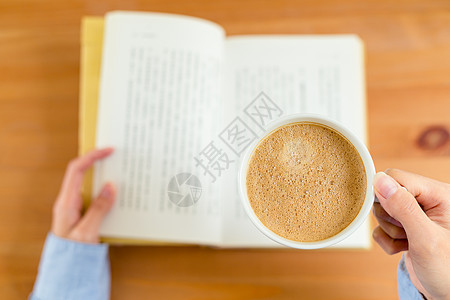 女性阅读书籍和享受咖啡的顶端景色图片