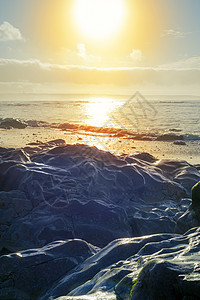热日落岩石的海浪图片