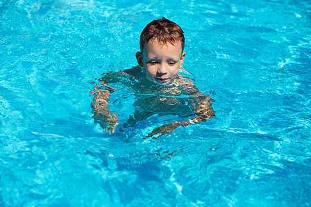 可爱的孩子 男孩在游泳池水中游泳图片