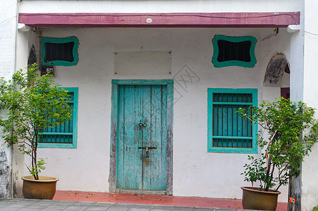 外表地中海风格 旧墙壁上的蓝木门和窗窗帘(George Town Penang)图片