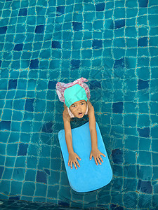 亚裔女孩尝试游泳游泳池游泳喜悦孩子风镜游泳者童年水池钻头运动学习游泳衣图片