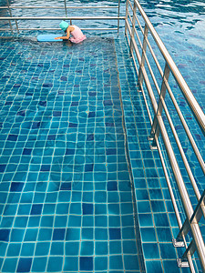 亚裔女孩尝试游泳游泳池游泳游泳衣童年水池喜悦学习孩子钻头风镜蓝色游泳者图片