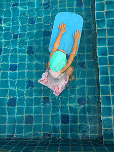 亚裔女孩尝试游泳游泳池游泳学习蓝色运动乐趣喜悦游泳衣水池风镜游泳者孩子图片