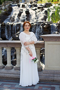 穿着昂贵的裙子穿时尚新娘女孩树叶女性已婚跑步花园公园金发女郎微笑幸福图片