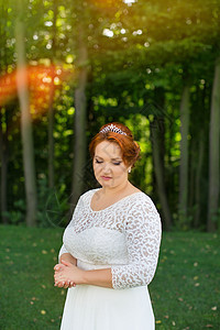 穿着昂贵的裙子穿时尚新娘跑步面纱微笑树叶金发女郎花园阳光女性已婚婚礼图片