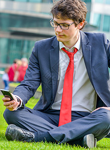坐在草地上的青年商务人士图片