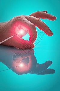 探测对象左手大手指和索引指之间的探针端的亮光源图片
