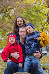 秋季公园有两个子女的家庭有两名子女乐趣享受父母拥抱女儿孩子们森林女孩女士农村图片
