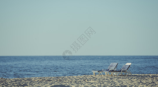 海滩的沙滩休息员在海滩上海岸女孩天空晴天蓝色海岸线躺椅旅行支撑地平线图片