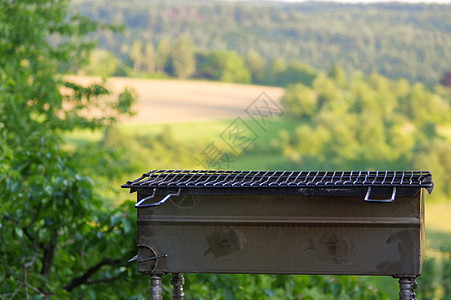 清空便携式BBQ烧烤炉 面对新鲜的绿色夏日风景 特写图片