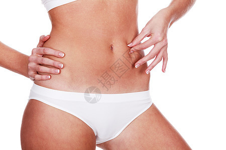 女人在肚子上捏着脂肪 孤立在白色背景图片