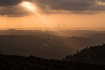 日落中的山层薄雾山峰地平线阴霾丘陵橙子射线情绪阳光风景图片