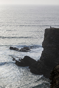 在悬崖上孤独的人自由环境岩石思维冥想海岸线海浪海洋男人海岸图片