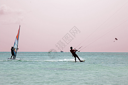日落时在阿鲁巴岛的加勒比海水域港男性乐趣风筝冲浪者冲浪风帆运动冲浪板男人海浪图片