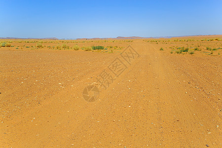 在摩洛哥沙漠的一条轨道上留下轮胎印象小路沙丘摩托四边形全景荒野车轮太阳旅行山脉图片