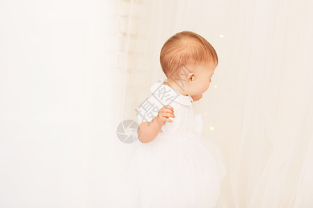穿着白裙子的漂亮女婴的肖像公主新年假期玩具幸福乐趣孩子微笑婴儿女性图片