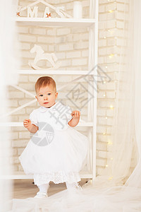 身着白礼服的美丽女婴 在内地与基督情感快乐童年幸福新年乐趣假期裙子婴儿庆典图片