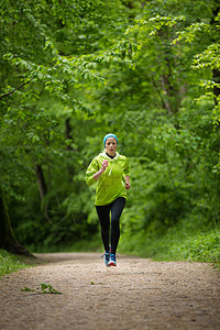 在森林里运动的年轻女性选手慢跑活力娱乐运动装女孩火车公园训练树木运动员图片