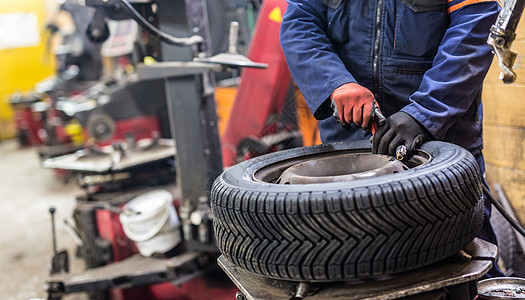 在汽车修理服务中 专业汽车机械师更换轮车轮胎扳手店铺机器工作服男性维修男人技术员车辆运输图片