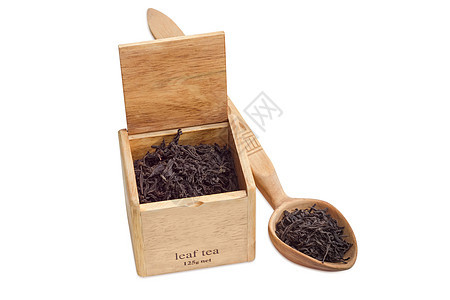 木箱和勺子中的黑茶叶长叶食物味道黑色泡茶盒子厨房树叶植物饮料背景图片