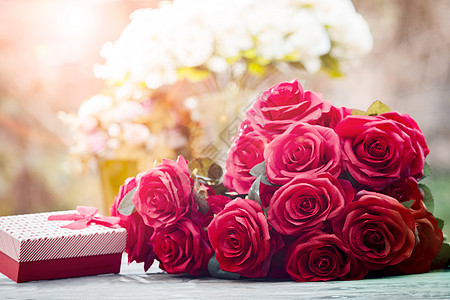 金边玫瑰红玫瑰花花 配有情人节礼物和美丽的鲜花背景