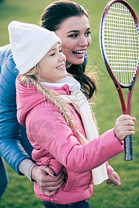 微笑的母亲与女儿玩羽毛球女孩闲暇家庭父母追求成人女士活动阳光季节图片