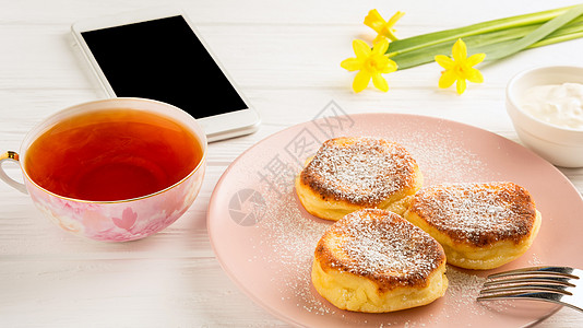 白色背景的煎饼 茶叶 花花和智能手机图片