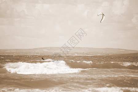 在美丽的波浪上冲浪的Sepia风筝图片