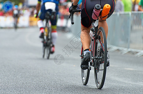 在自行车比赛中 无法辨认的专业骑自行车者 背面看台轮子竞争者运动运输领导者沥青男人速度挑战赛车手图片