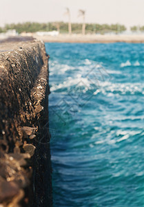 海浪拍打石墩模糊不清海滩旅行蓝色墙纸卵石飞溅石头地平线危险太阳背景图片