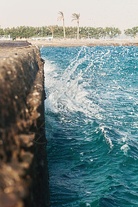 海浪拍打石墩模糊不清支撑泡沫海洋石头危险风暴阳光冲浪波纹巨石背景图片