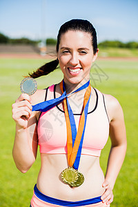 展示金牌的女运动员肖像运动服女士运动能力女性喜悦勋章晴天竞技丝带图片