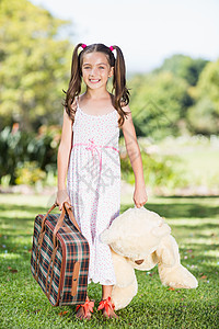 年轻女孩拿着手提箱和泰迪熊图片