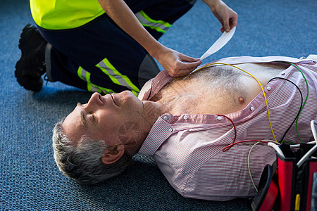 在心肺复苏期间使用外部去纤颤器的辅助医疗人员女性电气呼吸速度心脏病女士波形生存老年救援图片