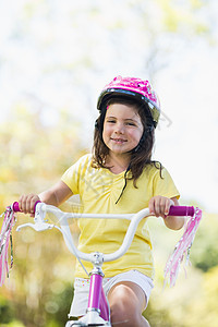 骑自行车的微笑女孩晴天享受女性活动骑术微笑公园服装安全阳光图片