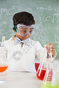 在实验室做化学实验的中校男学生班级化工学习小学混血男性专注课堂烧杯液体图片
