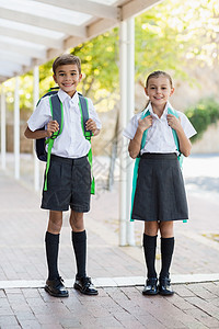 站在走廊上微笑的学校孩子快乐小学教育女性男生制服女学生童年门厅学生图片