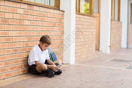 坐在走廊上并使用移动电话的男学生人数图片