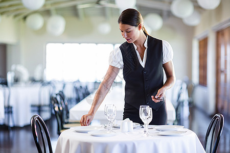 集装箱服务微笑的女服务员摆桌子女士玻璃餐厅盘子环境职业椅子服务马甲酒店背景