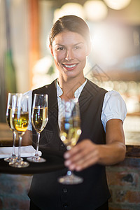 集装箱服务微笑的女服务员提供一杯香槟的肖像马甲服务茶点餐厅职业快乐制服长笛工作女士背景