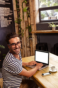 在餐厅使用膝上型电脑的青年男子男人金发女郎享受笔记本技术咖啡杯热饮乐趣电话食堂图片