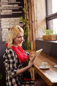 女青年在自助餐厅使用数字片板互联网咖啡杯热饮阅读平板女士技术潮人咖啡店女性图片