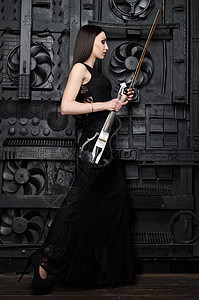一个女人站在摄影师的小提琴的侧面上图片