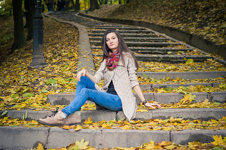 女孩坐在石阶上叶子树叶衣服真实性闲暇脚步女性青春期公园快乐图片