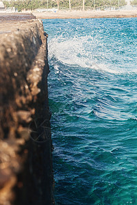 海浪拍打石墩模糊不清波浪泡沫冲浪情绪海洋阳光飞溅海滩卵石波纹背景图片