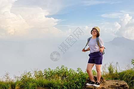 登山时的旅游少女服装场景女士公园旅行眼镜游客天空姿势风景背包图片